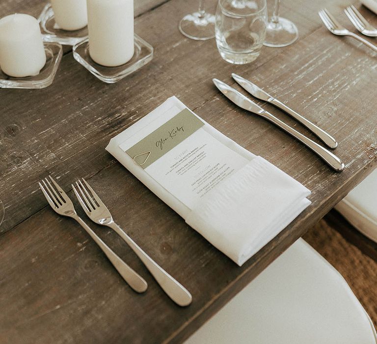 Classic white stationery on wooden banquet table for marquee reception