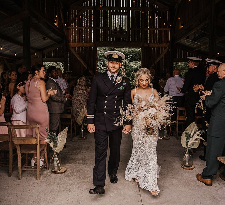 Rustic barn wedding at Nancarrow Farm with the bride and groom walking back down the aisle as a married couple