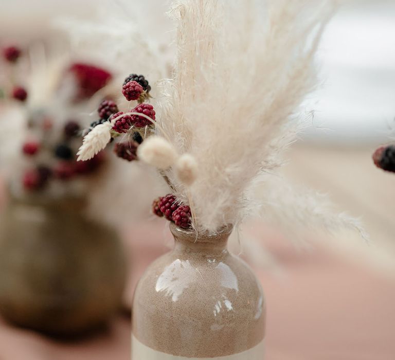 Pampas grass arrangements line wooden tables 