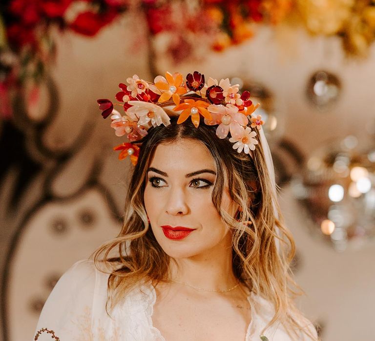 Bride holding pink garden rose, pampas grass, carnations, baby's-breath, dried flower and foliage bridal bouquet wearing three quarter length sheer sleeve wedding dress with button and cinched waist details and pink bridal flower crown 