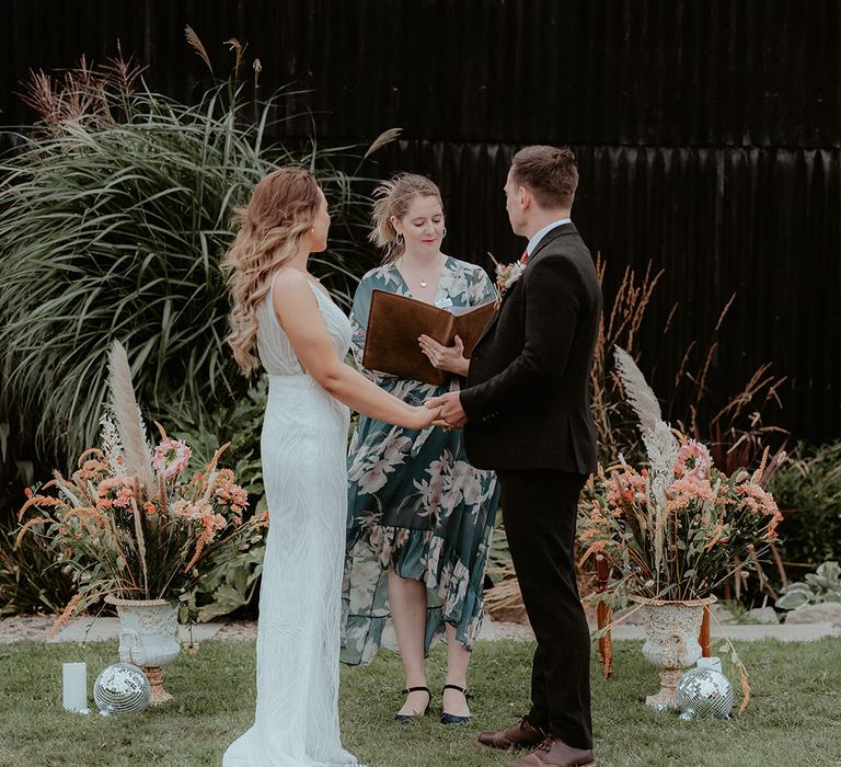 Humanist wedding celebrant stand with the bride and groom at their outdoor wedding ceremony at Rhyse Farm 