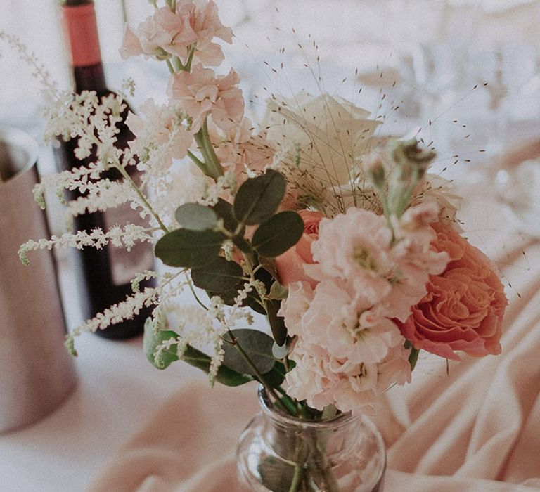 Peach, pink, and white wedding flower decorations for the wedding tables at the pink theme rustic luxe wedding 