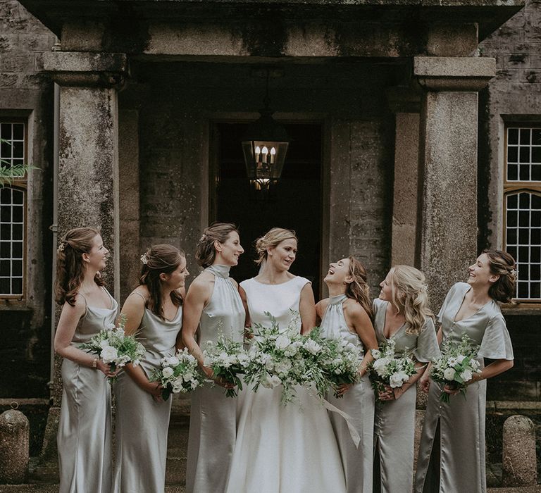 Bride in San Patrick wedding dress with the bridal party in sage green satin halter neck bridesmaid dresses 