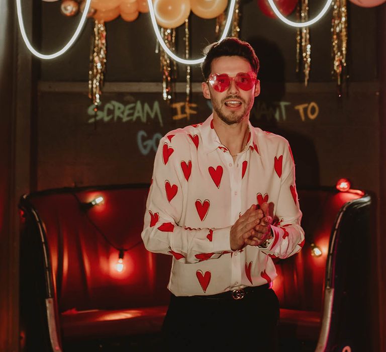 Groom in funky red heart patterned shirt with red heart sunglasses for retro wedding 