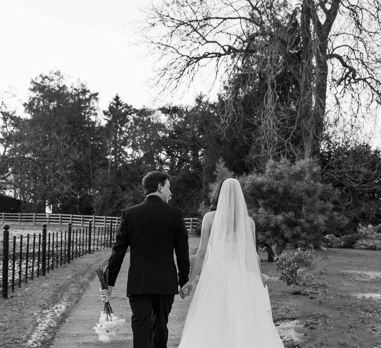 Bride and Groom walk hand in hand at Upton Barn & Walled Gardens wedding venue