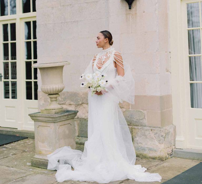 Bride in low v-neck slip bridal dress with dramatic pearl necklace and accessories, detachable tulle sleeves and tulle puddle train at Settrington Orangery editorial shoot