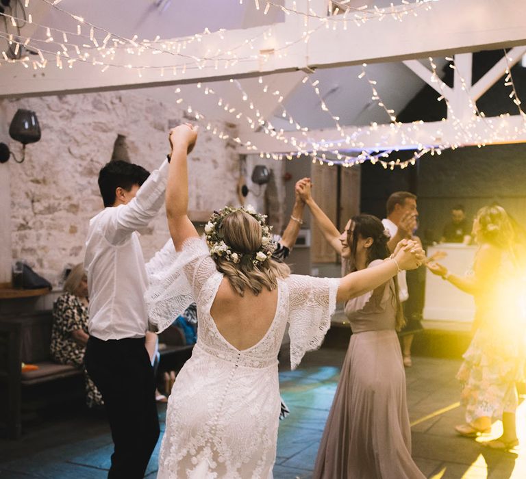 The bride dances on the dance floor with wedding guests at the reception 