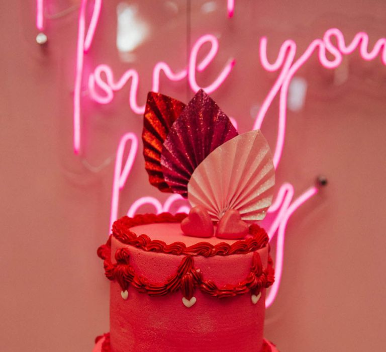 Magenta pink two tier wedding cake with sparkly palm leaf cake topper with neon sign 