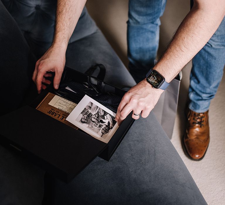 Groom unwraps a wedding present on the morning of the wedding 