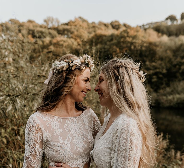 Two brides in long sleeve boho lace wedding dress with flower crown hair accessories 