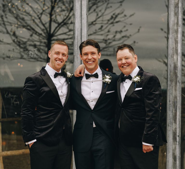 Groom and groomsmen in black tuxedos for country theme western wedding day 