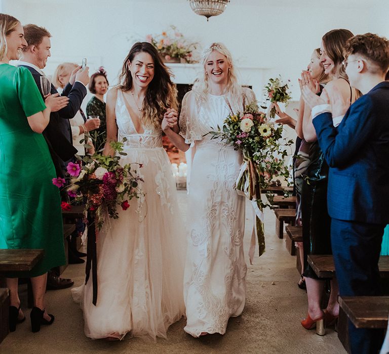 Brides in lace wedding dresses walking back down the aisle at Aswarby Rectory venue in the East Midlands 