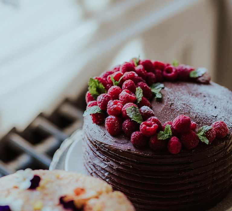 Layered chocolate wedding cake decorated with raspberries 