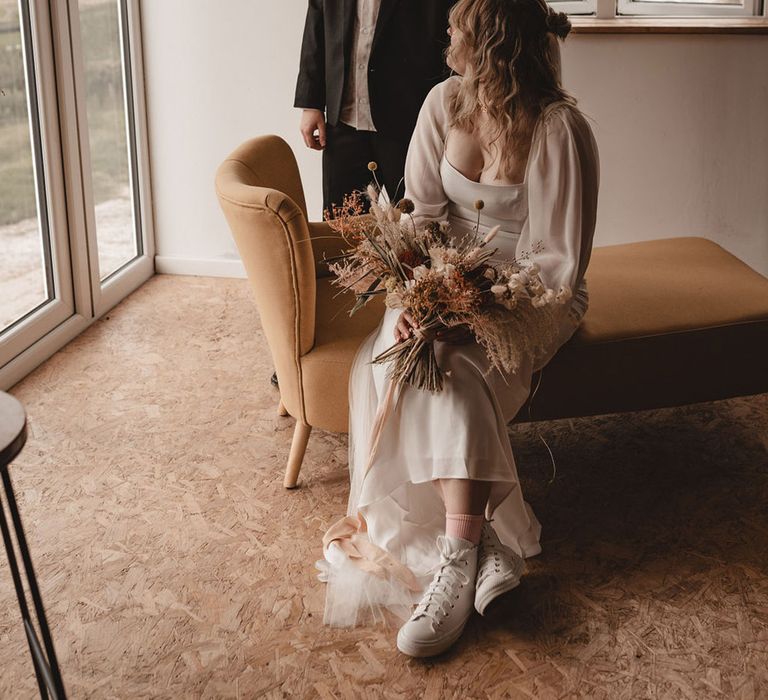 Lesbian wedding at The Giraffe Shed with one bride in a long sleeve wedding dress and other bride in suit 