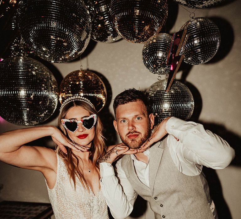 Gold and silver disco balls decorations with lightning bolts with the bride and groom having flash couple photos 