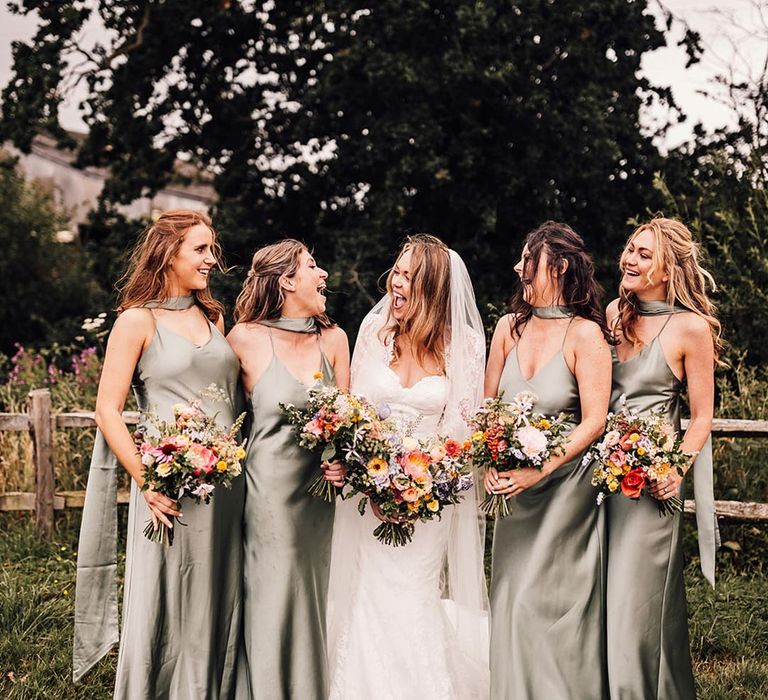 bridal party wearing green satin bridesmaid dresses 