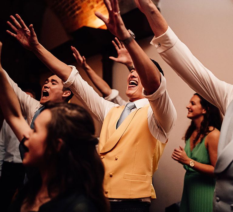 The wedding guests dance at the wedding reception 