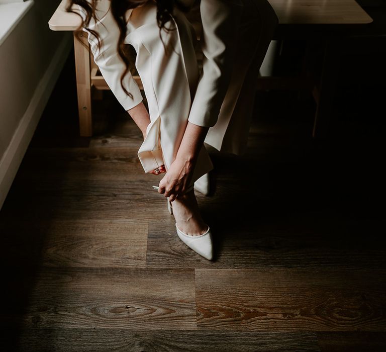 The bride puts on her wedding shoes as she gets ready for the big day 