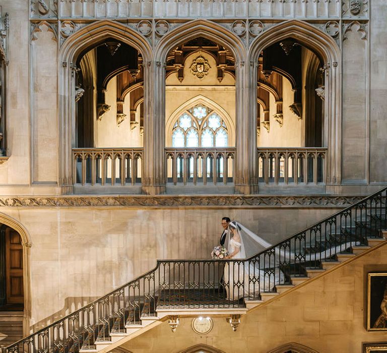 Bride walks down the aisle staircase to the groom led by her father 