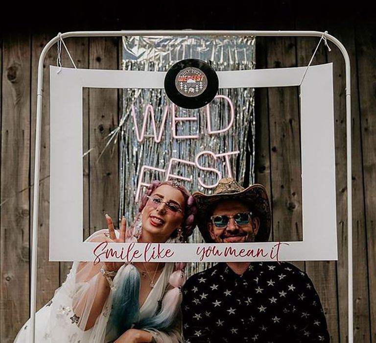 Bride and groom posing in a photo booth 