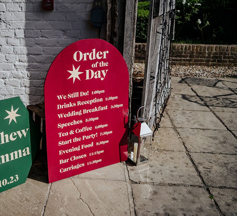 Red and green order of the day wedding signage for autumnal maximalist wedding 