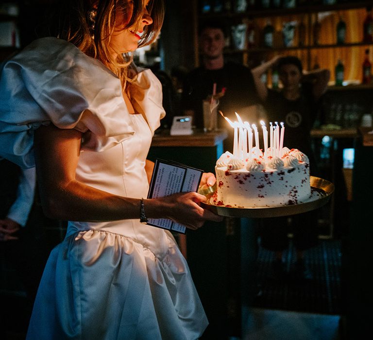 Bride comes out with birthday cake for the wedding weekend 