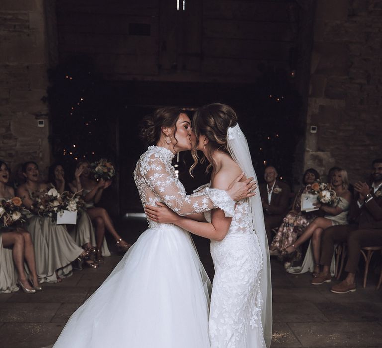 The two brides share their first kiss as a married couple at their Stone Barn wedding ceremony 