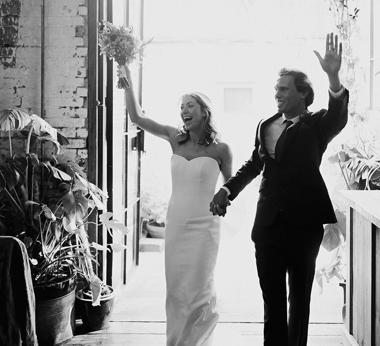 The bride and groom enter their wedding reception together celebrating 