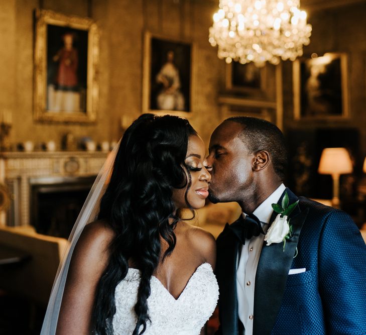 Groom in navy tuxedo kissing his brides cheek 