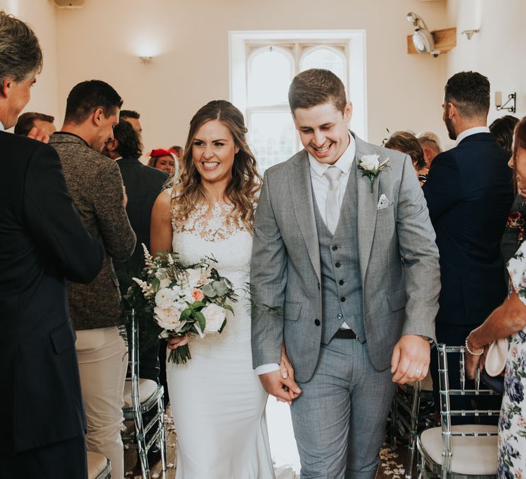 Bride and groom descending down the aisle as husband and wife 