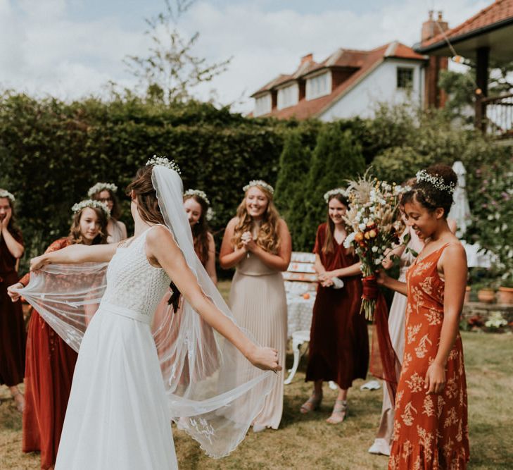 bride showing her bridesmaids her wedding dress and veil 