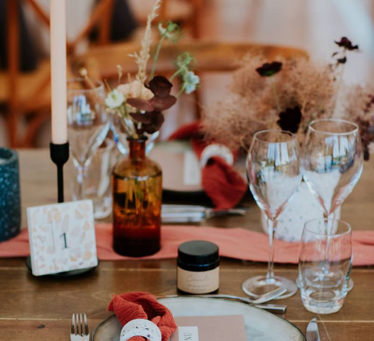 Place setting with coloured tableware and napkins and terrazzo menu card 