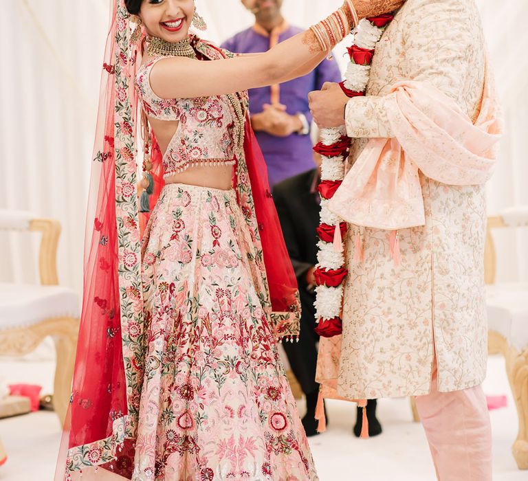 Bride putting a the flower jai mala on her groom