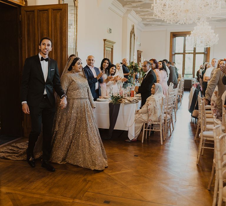 Bride and groom entering their multicultural wedding reception 