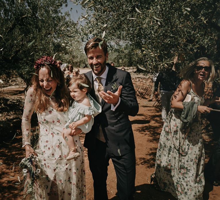 Bride and groom surrounded by olive leaf confetti