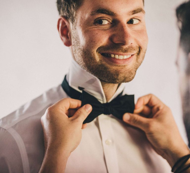 Groom getting ready for Tuscany Italy Wedding with bow tie