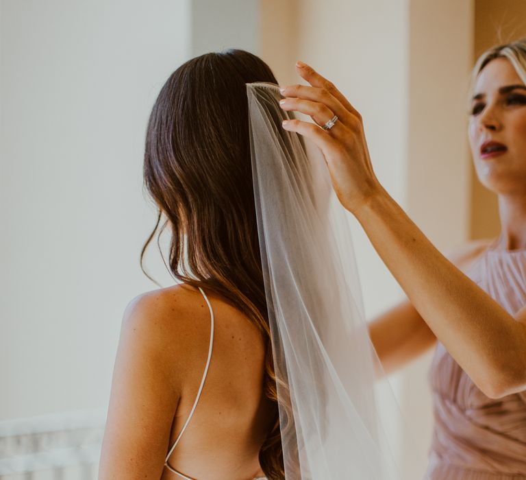 Bride having her veil fitted for outdoor wedding