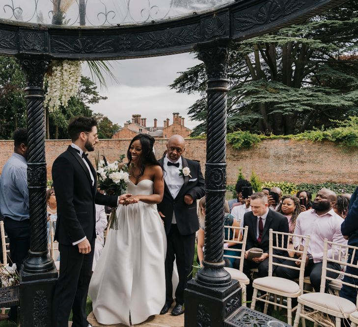 Bride greeting her groom at the altar of outdoor wedding 