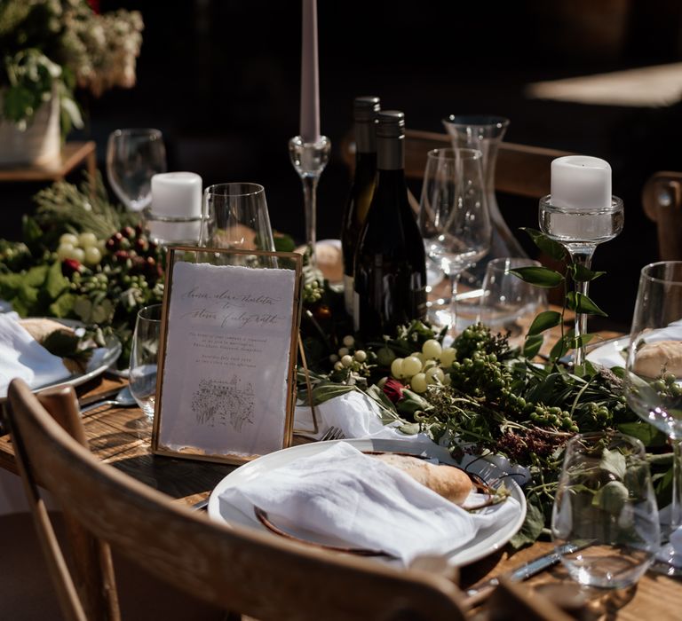 Foliage and grape training centrepiece decor and gold framed menu 