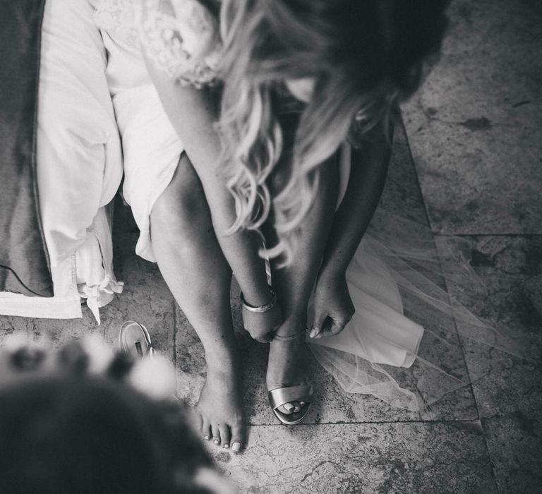 The bride fastening her wedding heels