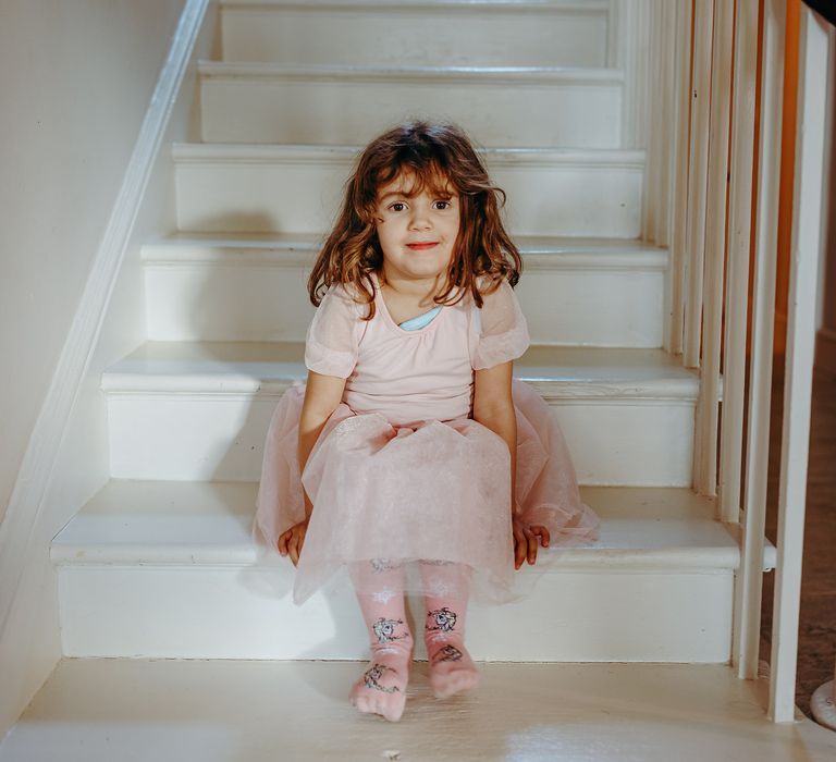 Flower girl sits on the stairs