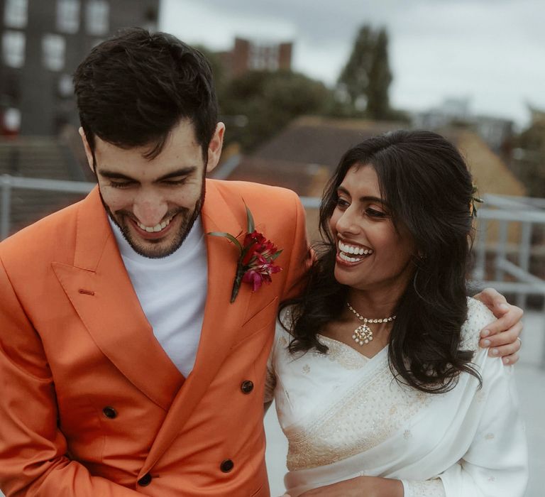 Bride and groom portrait by Millar Cole Photography with the Turkish groom in an orange suit and the Sri Lankan bride in a white sari