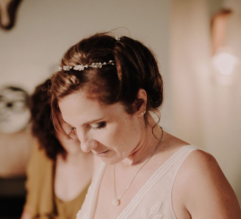 The bride wearing a beautiful wedding dress with floral beading details on the bust