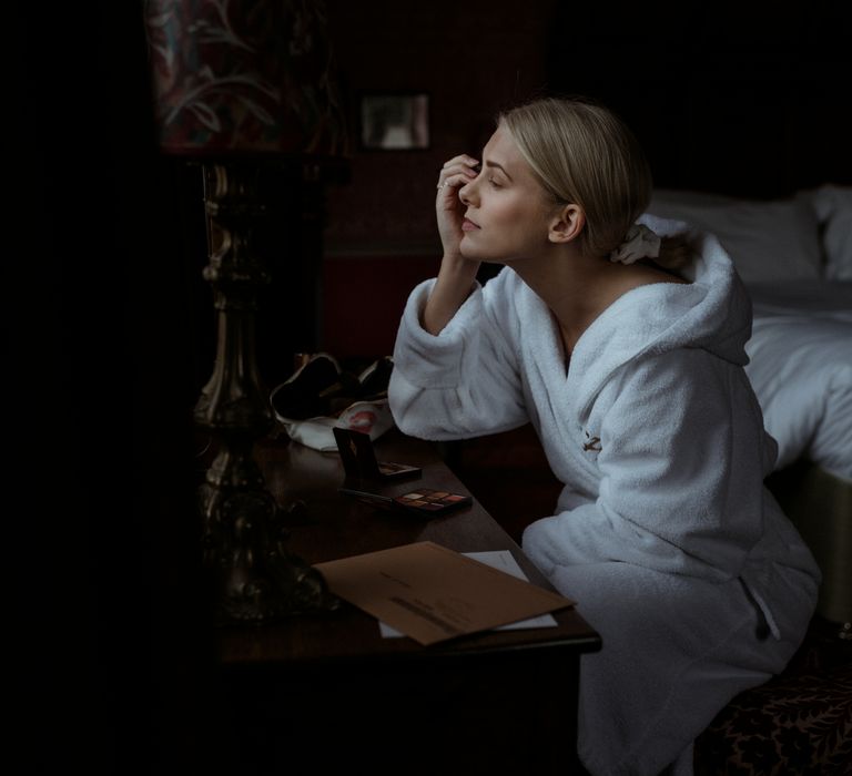 Bride does her makeup on the morning of her wedding