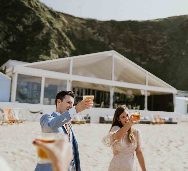 Bride and Groom raise a glass to their wedding day at Lusty Glaze in Cornwall