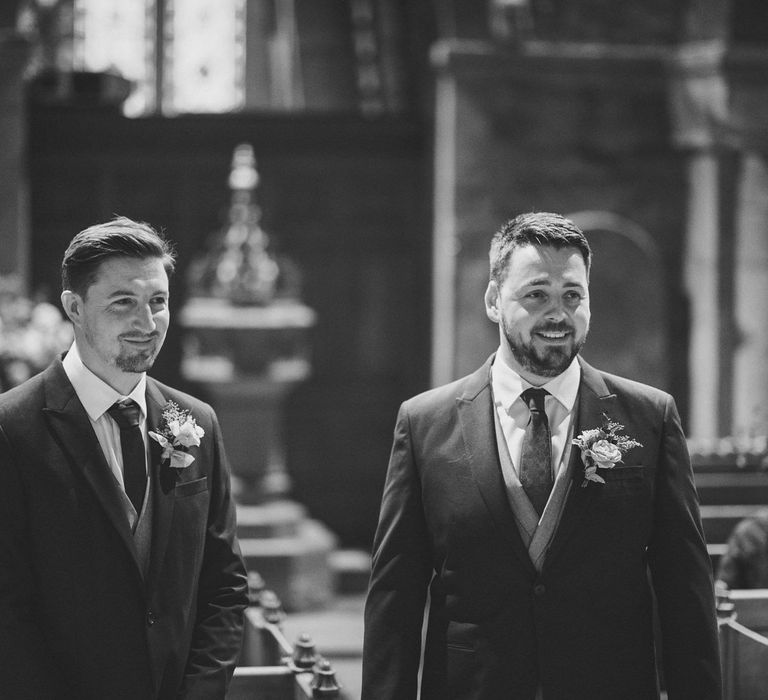 Groom smiling as his bride enters the church wedding ceremony 