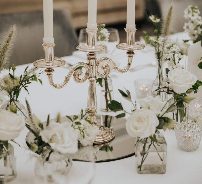 Lit candles burn as they are held in silver candle holder