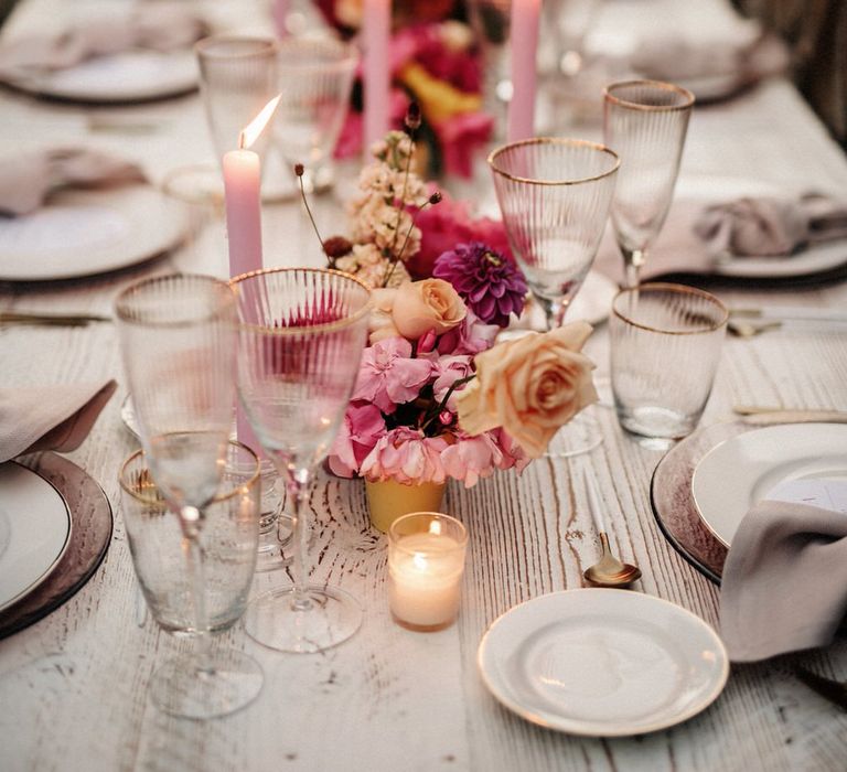 Tealights on pink and white banquet table with pink tapered candles