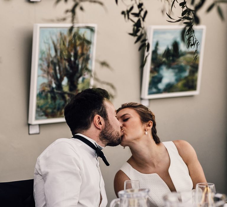 Bride & groom kiss during wedding reception