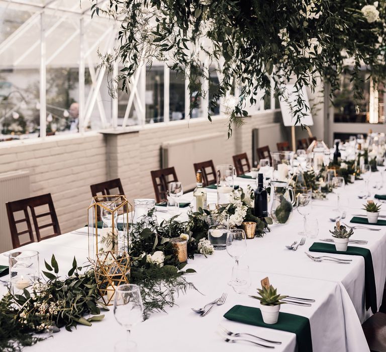 Orangery complete with elegant table settings and floral installation above